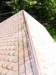 Sea green slate roof with copper ridge.